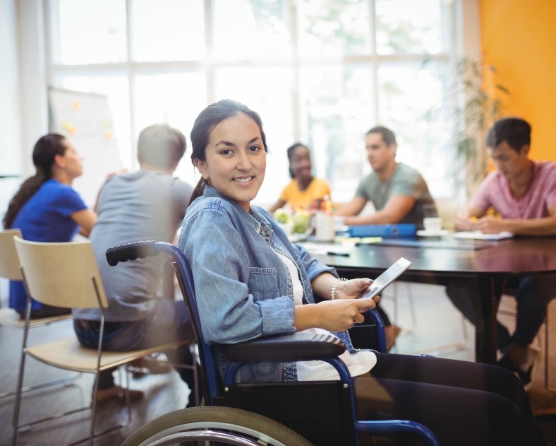 Portrait of handicapped business executive using digital tablet in office